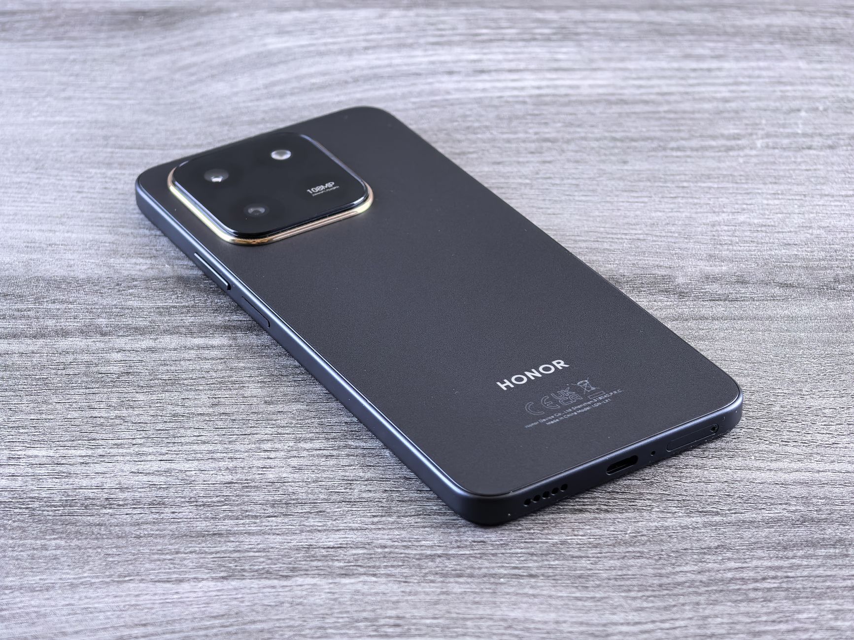 Close-up of a modern smartphone with a sleek design on a wooden surface.