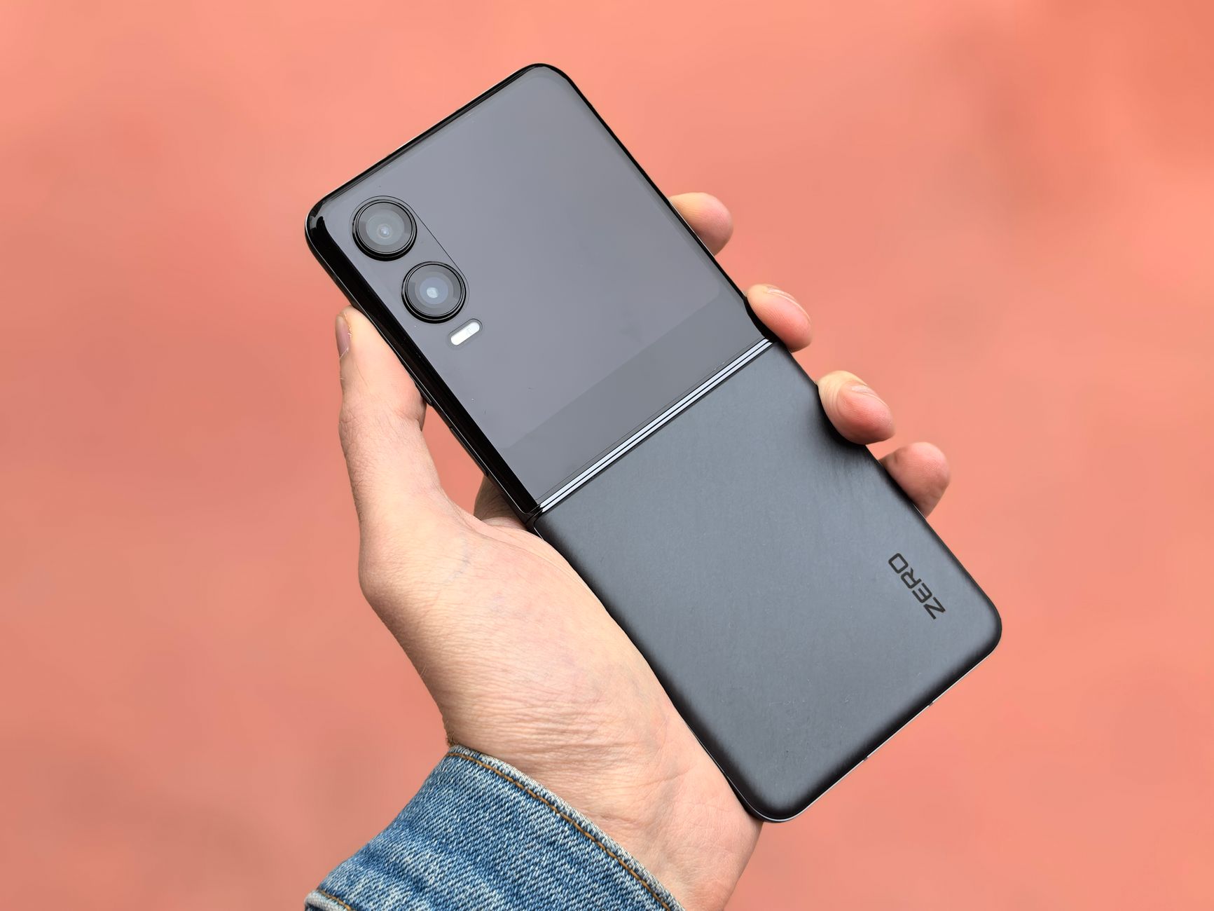 Close-up of a hand holding a modern black flip smartphone, ideal for tech and lifestyle concepts.