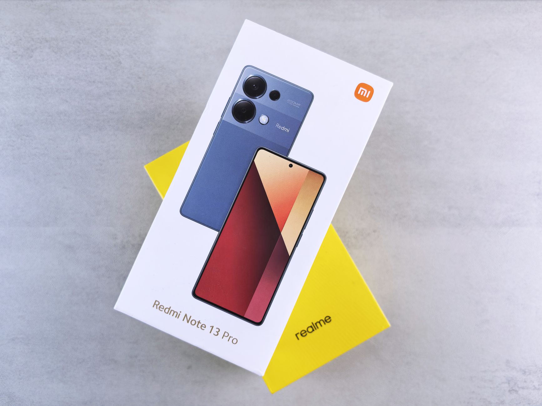 Close-up of Redmi Note 13 Pro phone box with sleek design on neutral background.