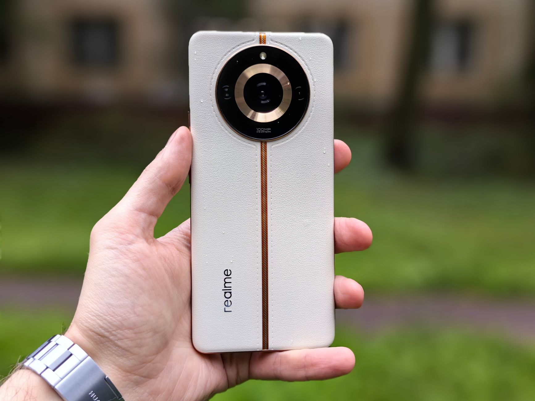 Close-up of a white smartphone held in hand outdoors. Modern technology amidst nature.