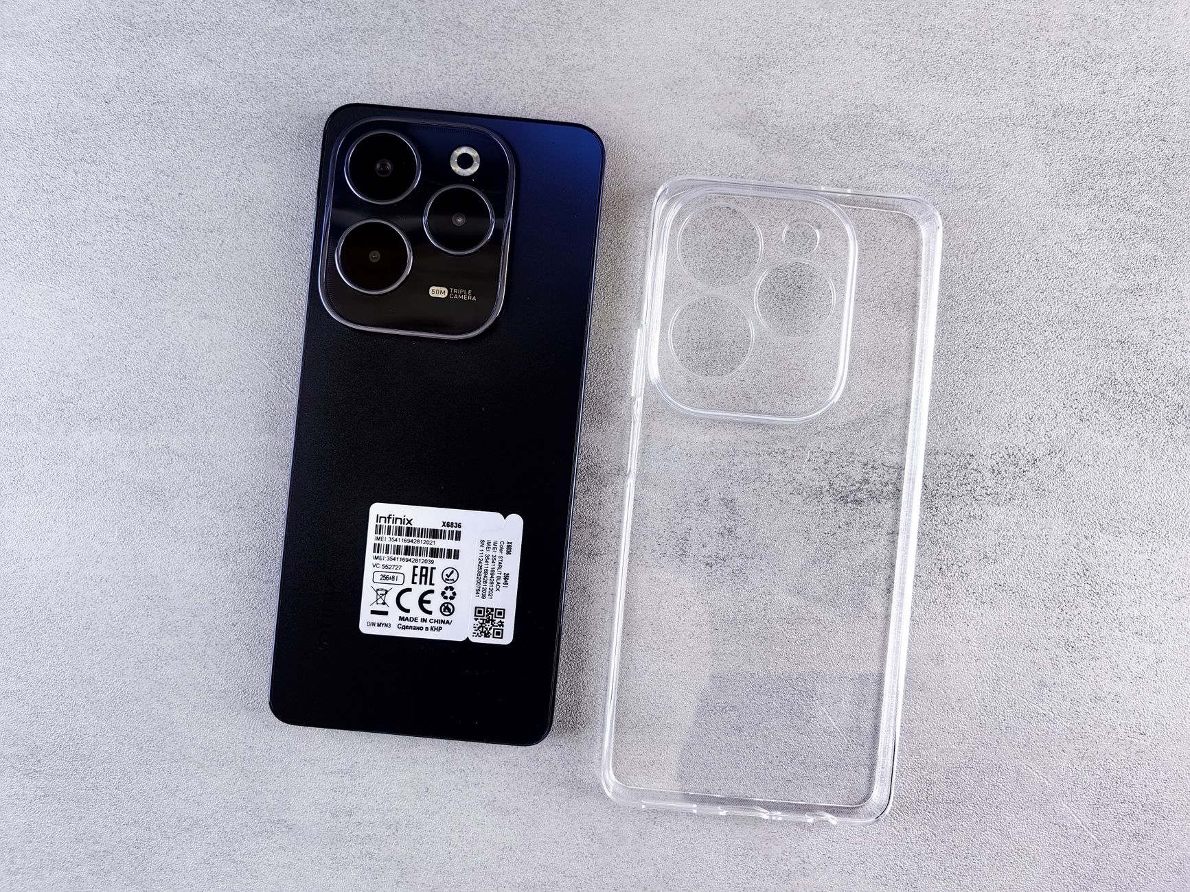 Top view of Infinix Hot 40 Pro smartphone with transparent clear case on a light background.