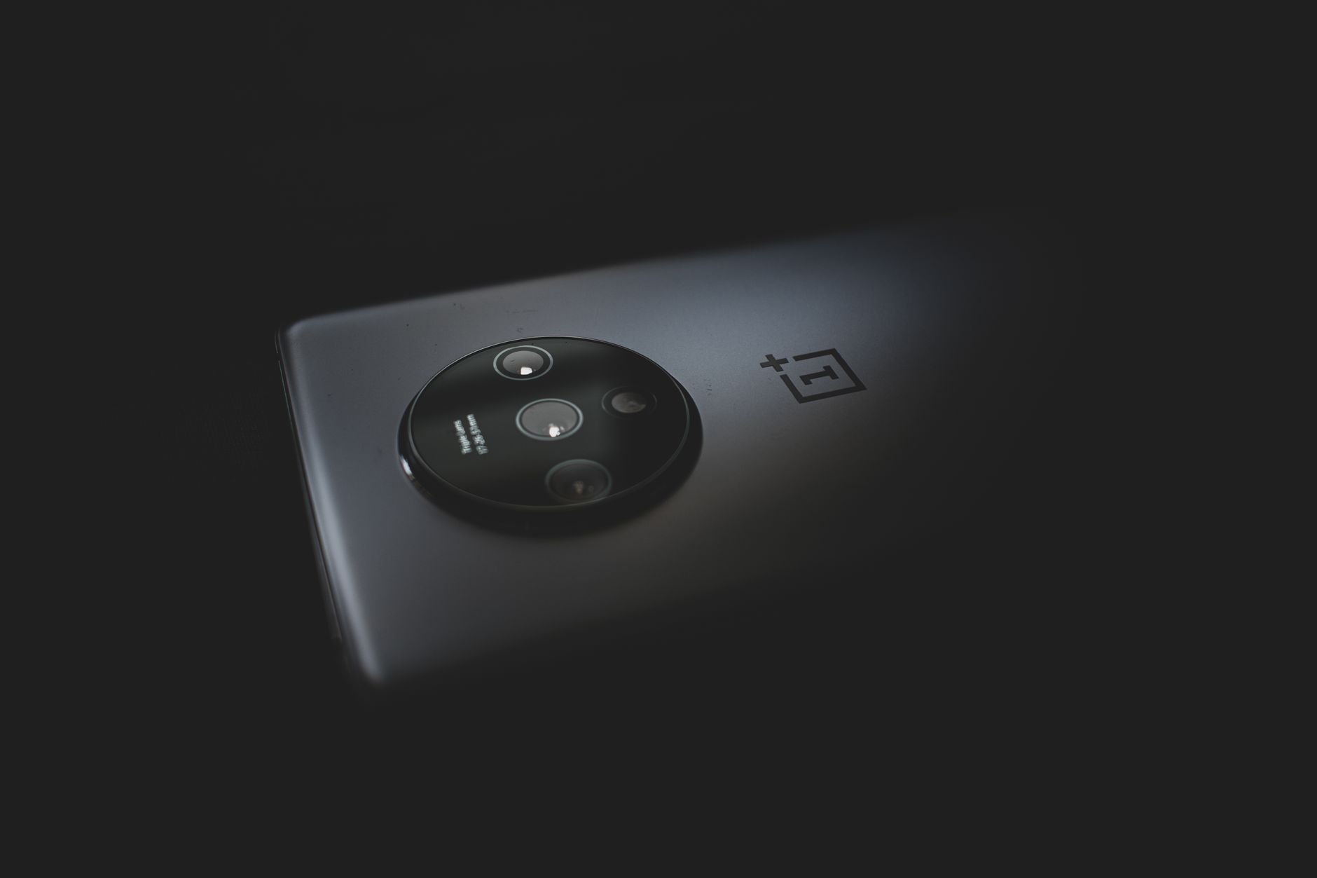 Detailed close-up of a modern smartphone camera against a dark background.
