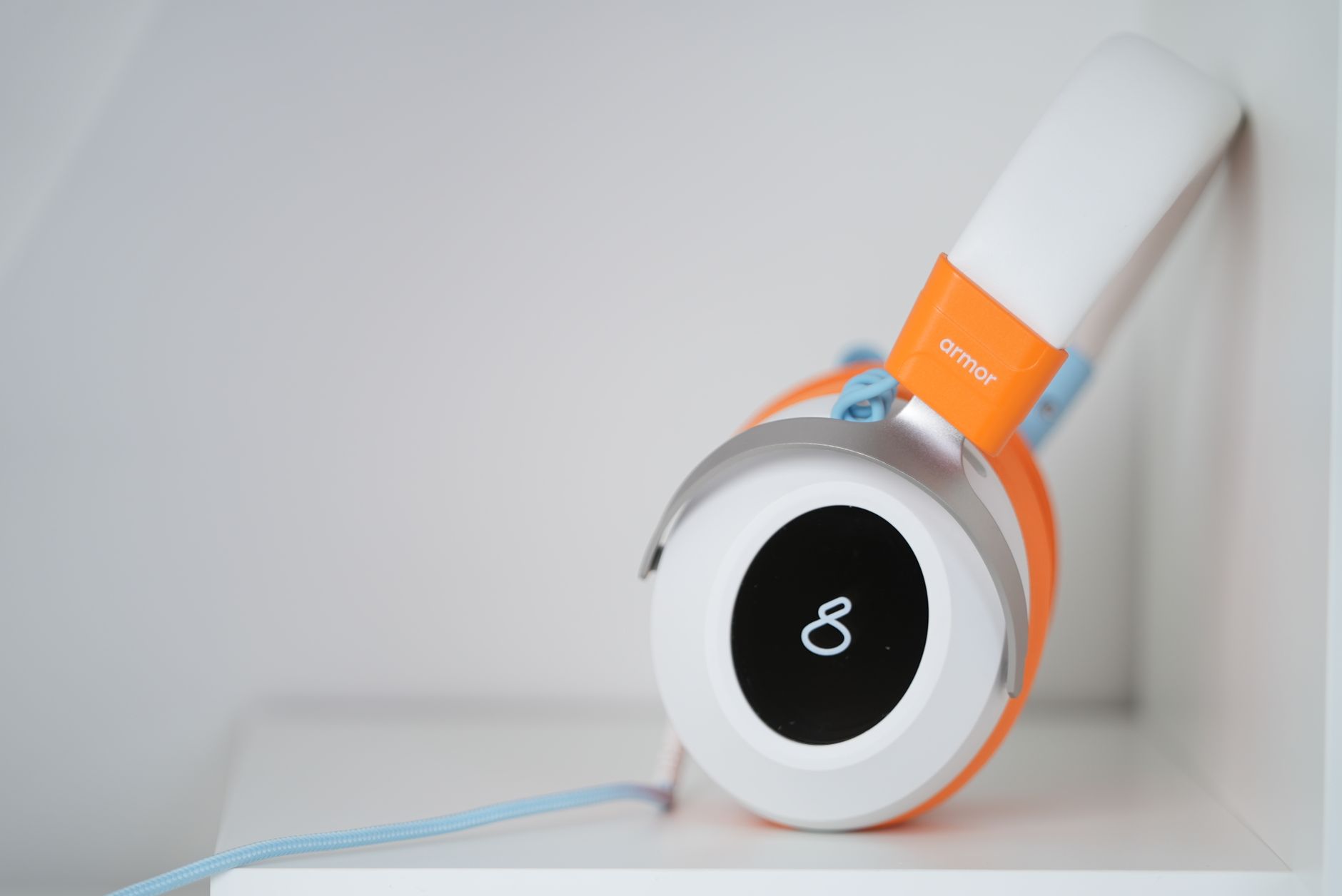 Close-up of stylish orange headphones featuring an infinity symbol on the ear cup.