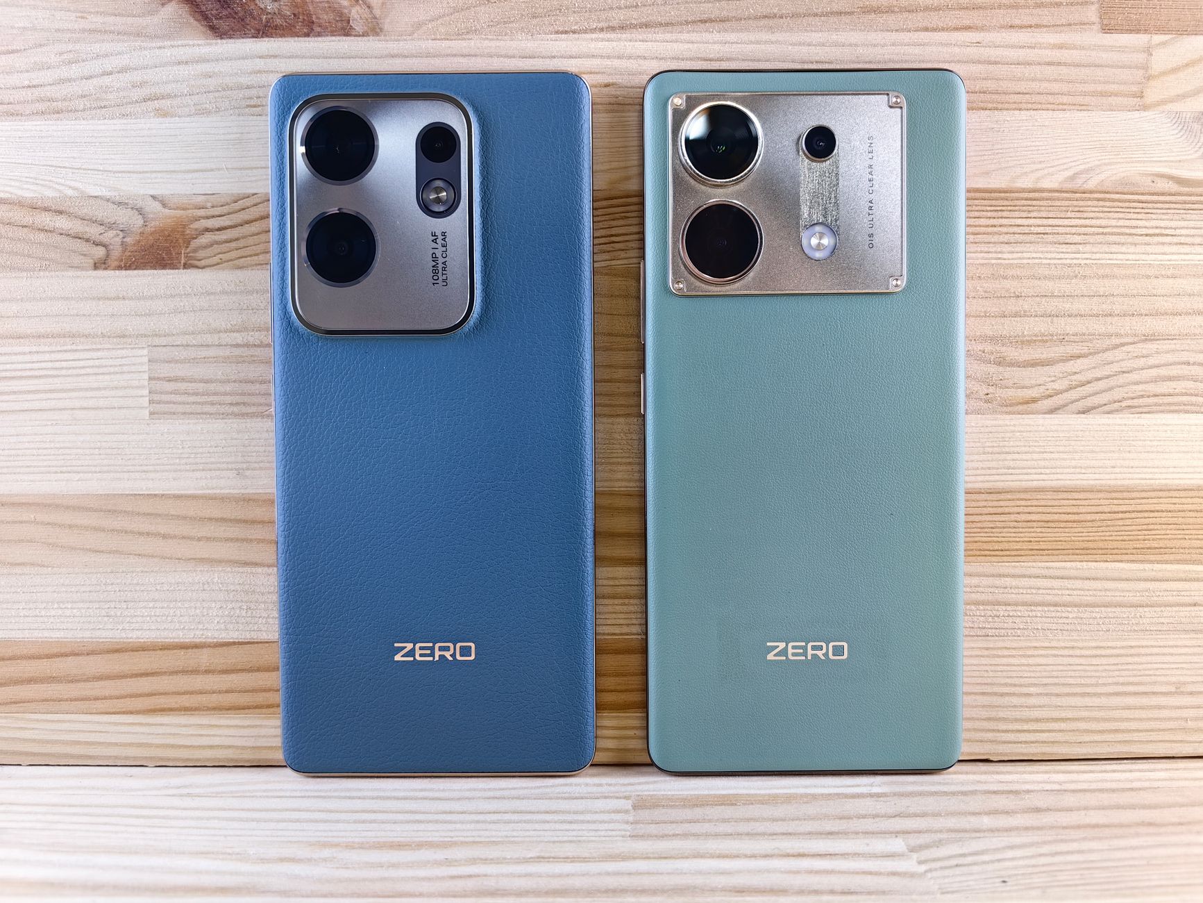 Two smartphones with 'ZERO' branding placed on a wooden surface showcasing their back designs.