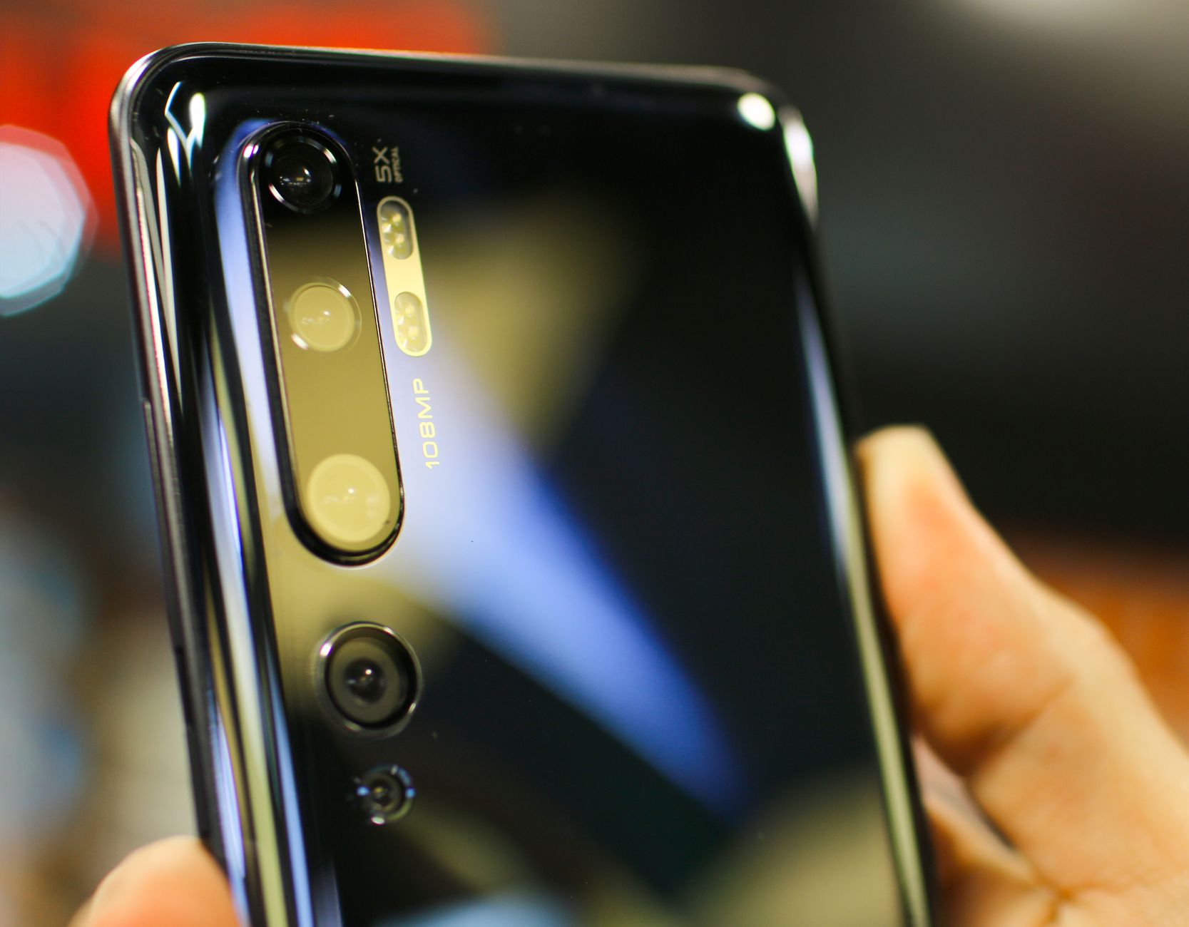 Detailed close-up of a smartphone camera lens reflecting light, showcasing advanced technology.