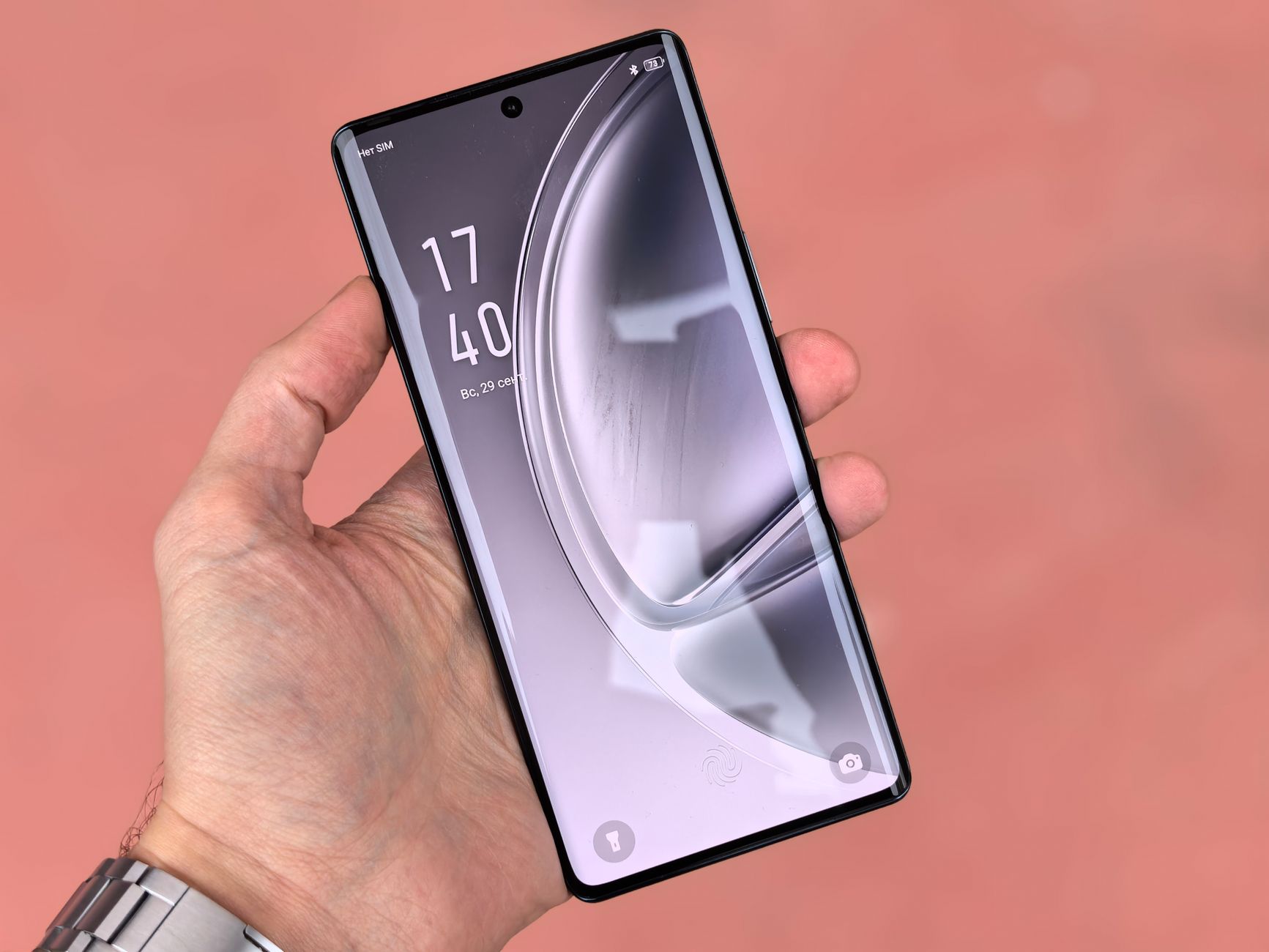A close-up image of a hand holding a sleek modern smartphone with a curved screen.