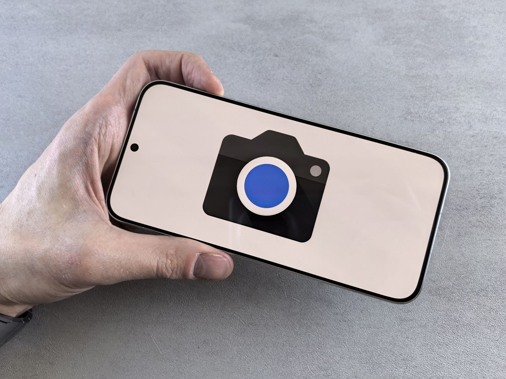 Close-up of a hand holding a smartphone displaying a camera icon, ideal for tech-related content.