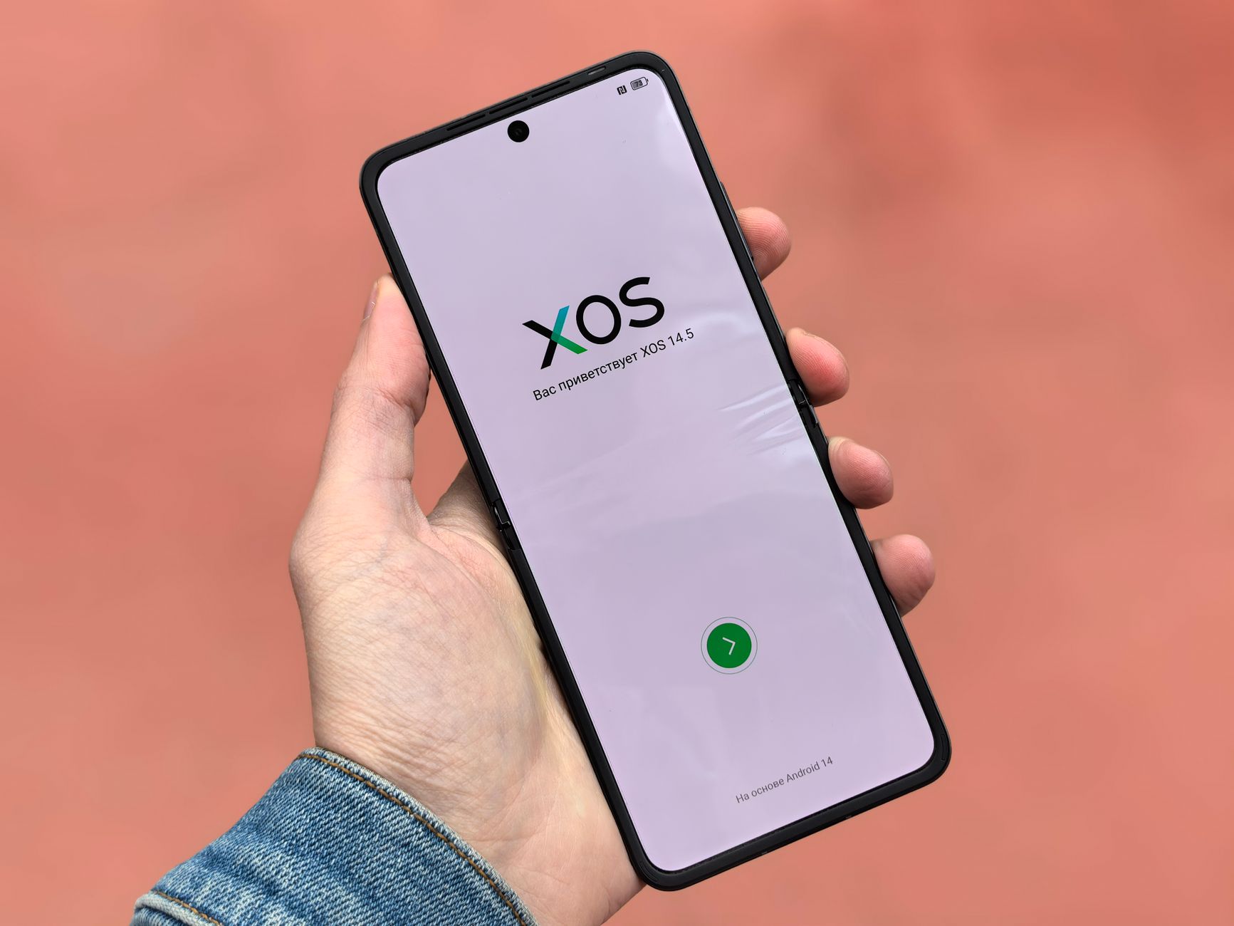 Close-up of a smartphone displaying the XOS 14.5 operating system interface in a hand.