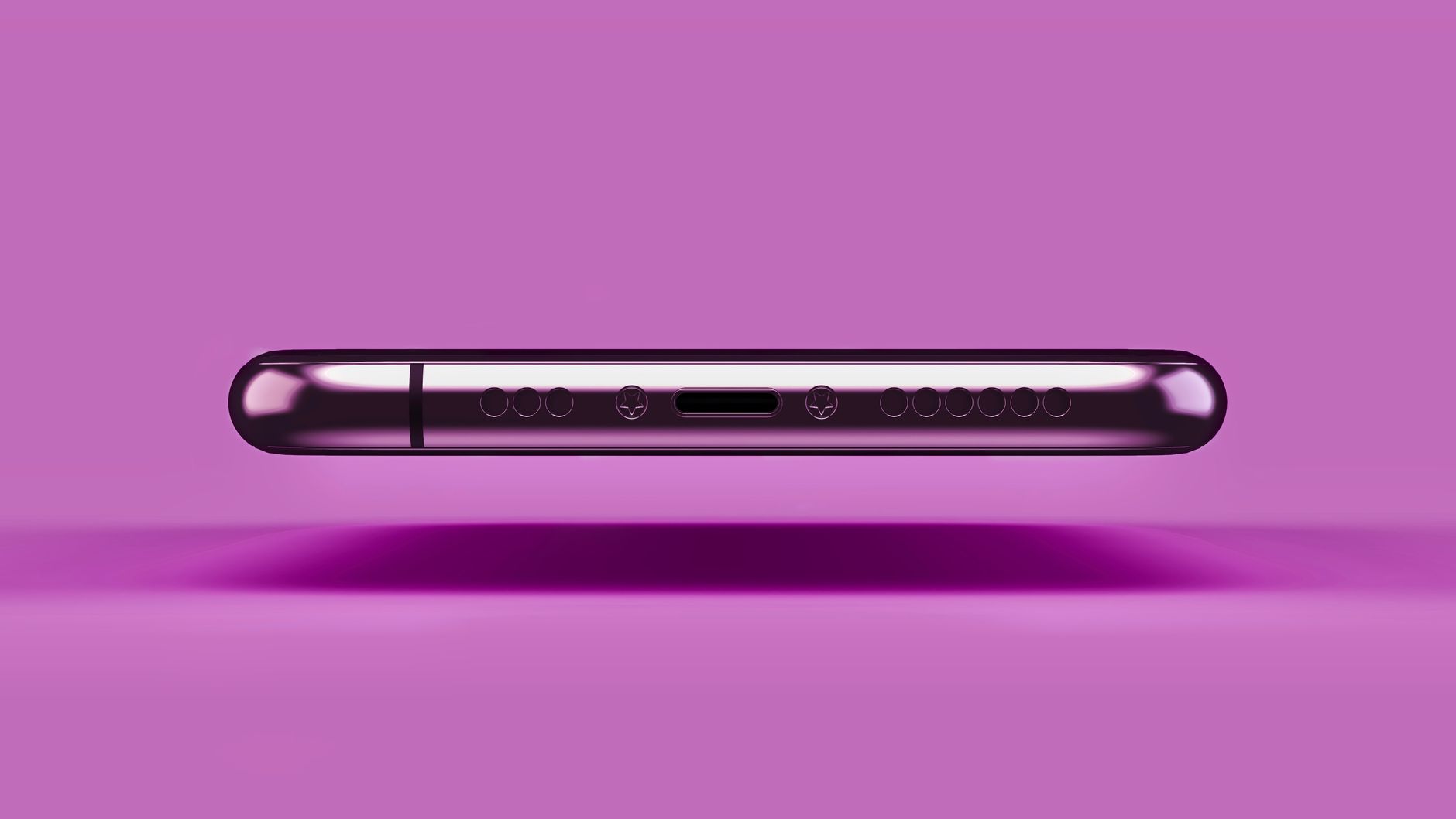 A sleek metallic smartphone resting on a vibrant pink background in a studio setting.