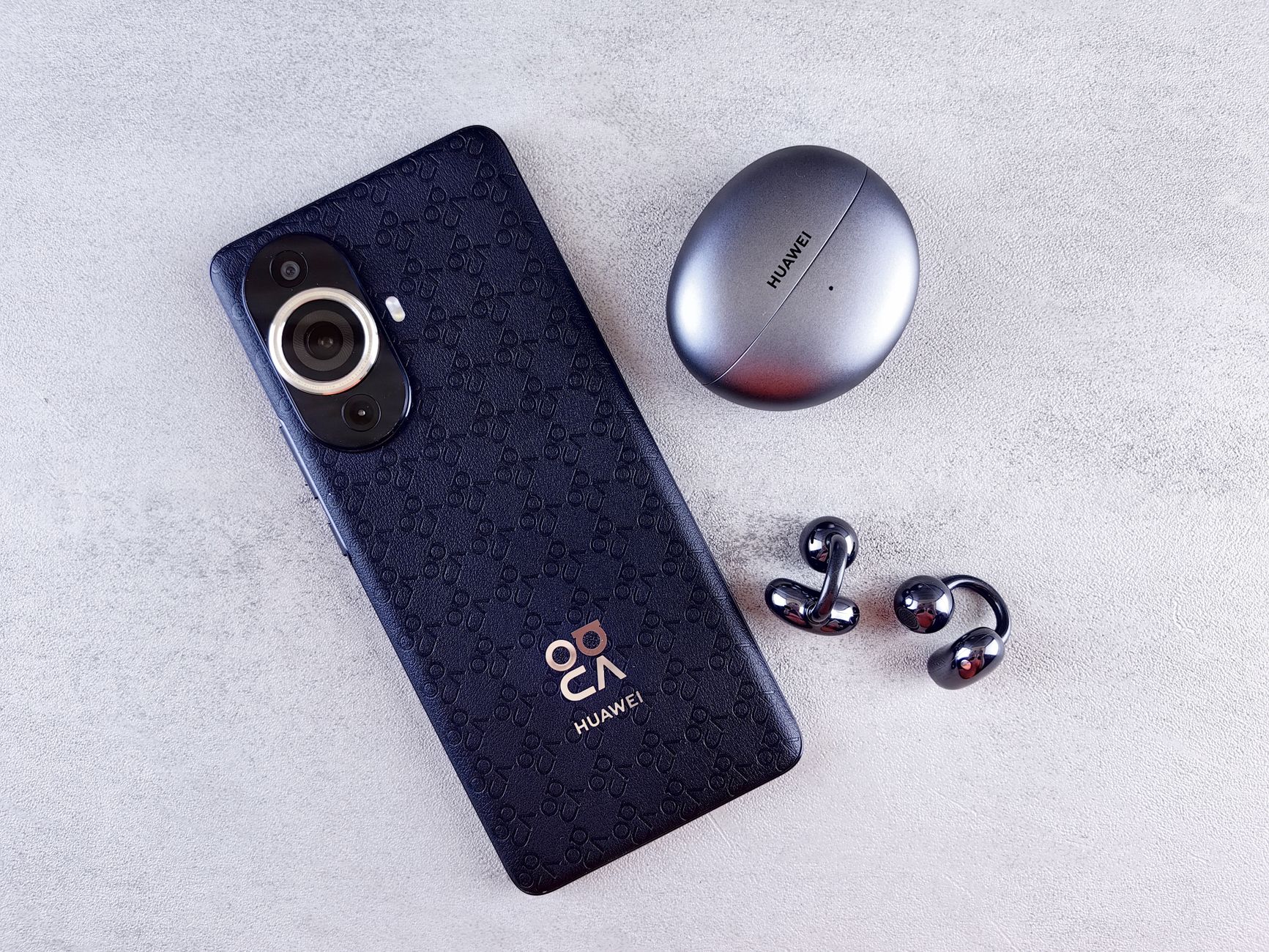 Stylish smartphone with case and metallic earphones on a textured gray background.