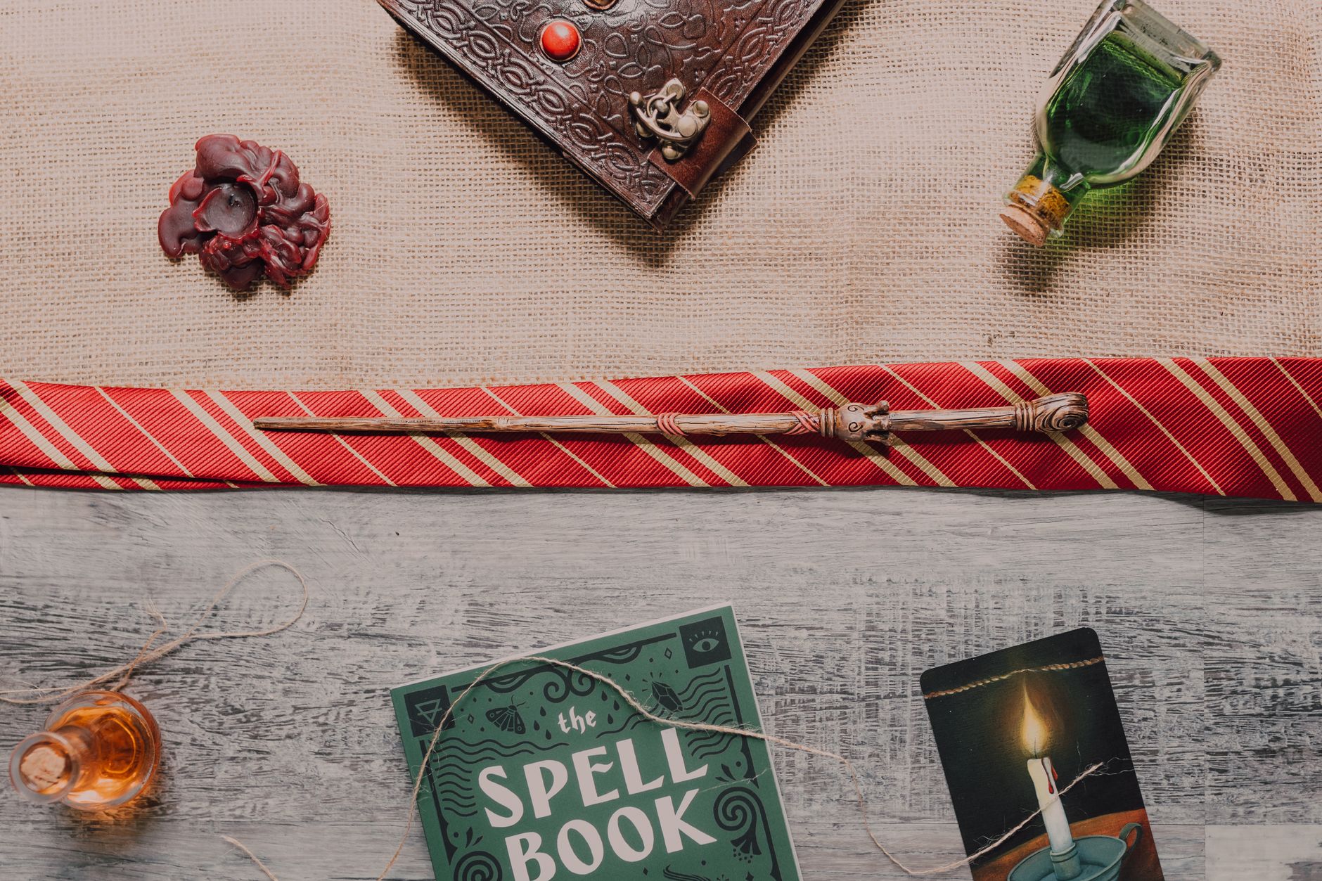 A collection of wizarding items including a spellbook, wand, and potions in a flat lay arrangement.