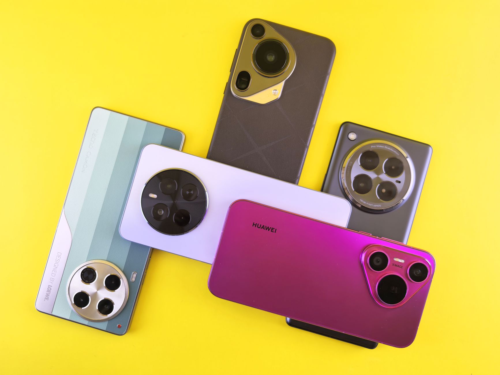 A collection of colorful smartphones arranged on a bright yellow background, showcasing modern design.