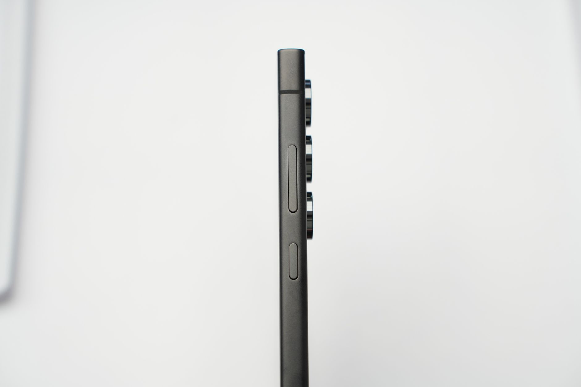 Minimalist side profile shot of a modern slim smartphone highlighting its camera lenses.