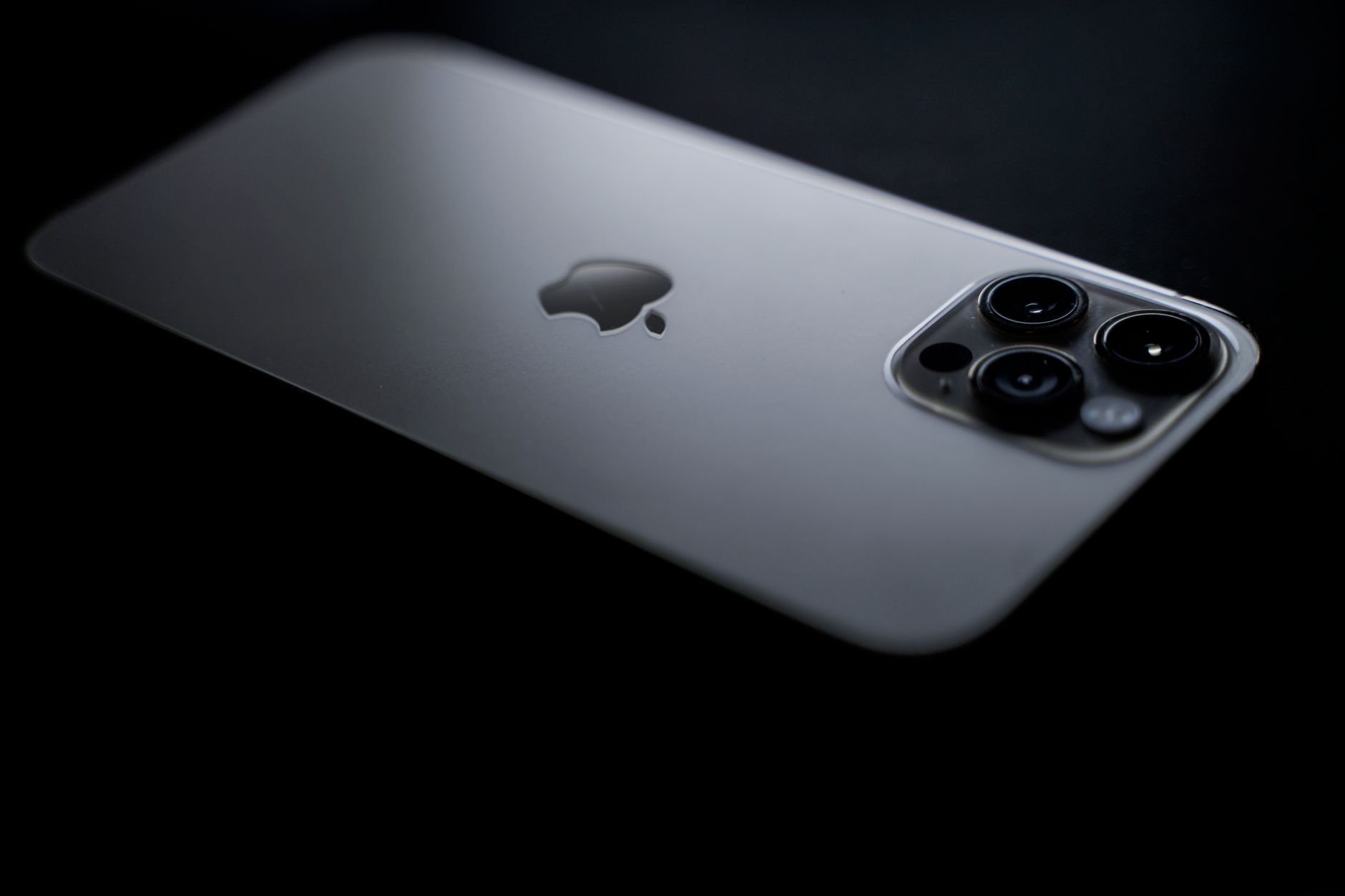 Close-up shot of a sleek smartphone showcasing triple camera lenses on a dark background.