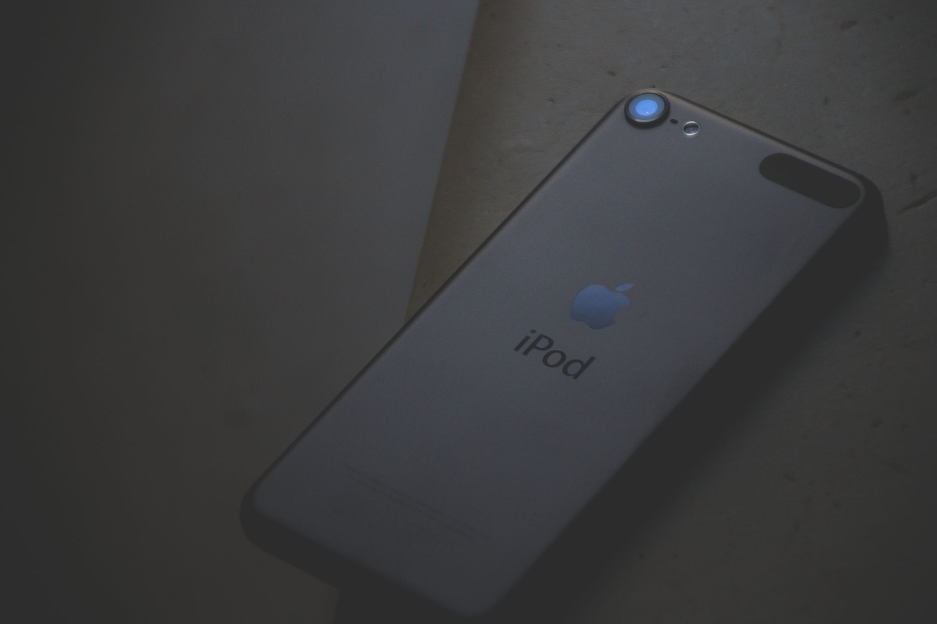 A dark and moody close-up of an Apple iPod showcasing sleek design and branding.